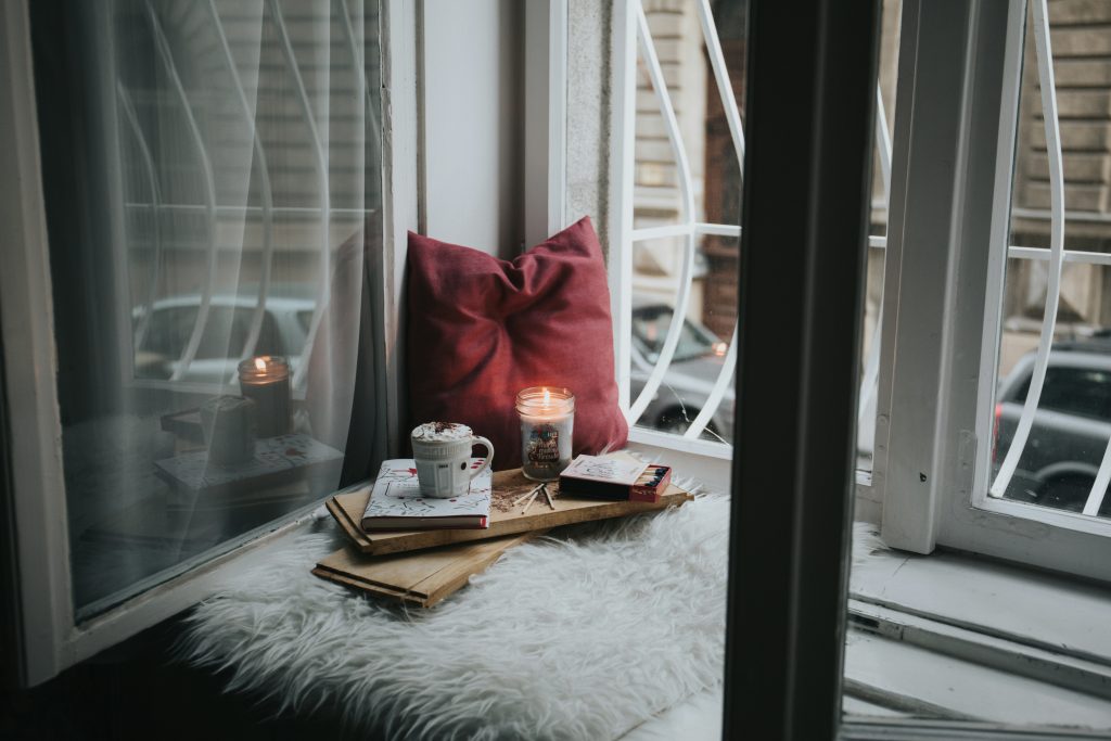 cozy self care corner with candle and pillow