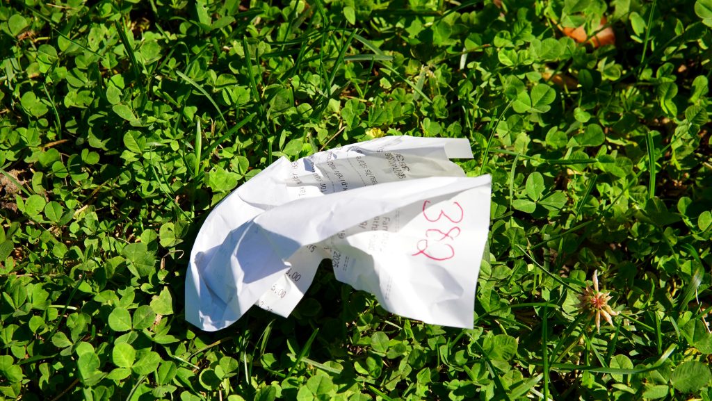crumpled up receipt in grass for junk journal