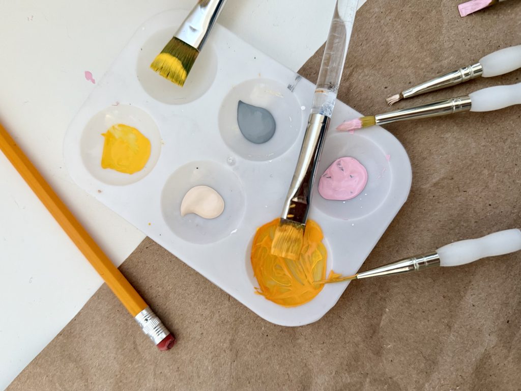 plastic paint palette with paintbrushes and pencil