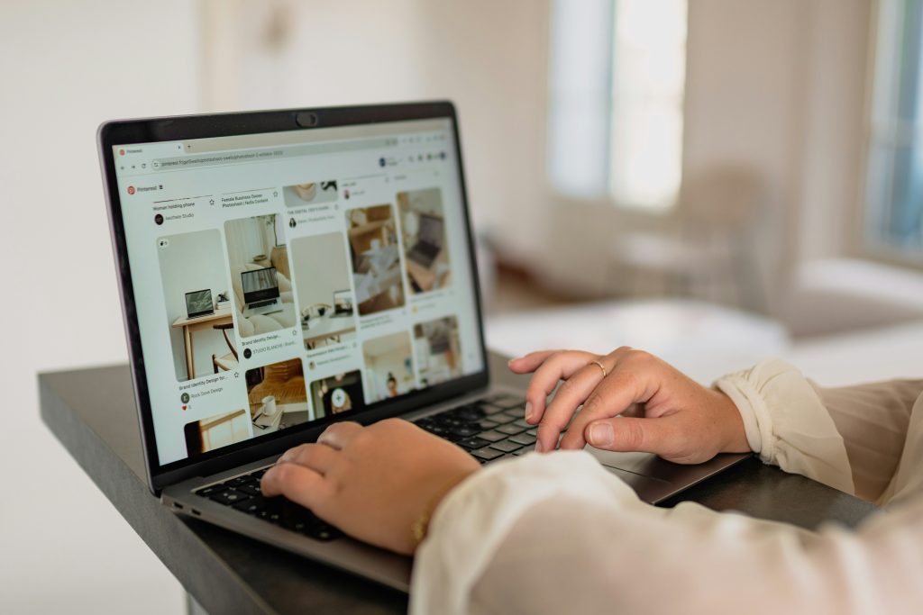 a person's hands on a laptop while viewing Pinterest