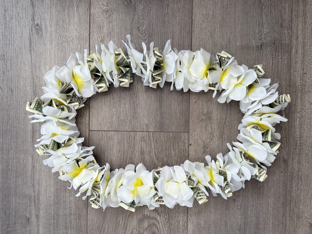 white artificial flower and money lei