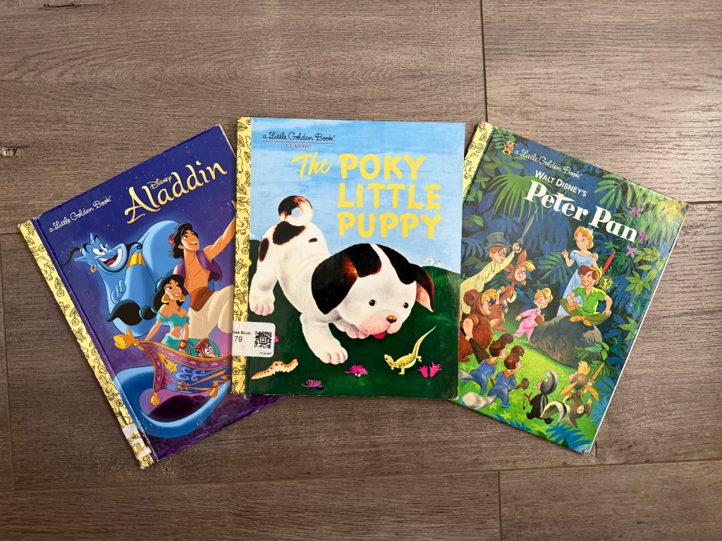 three little golden books on wood surface