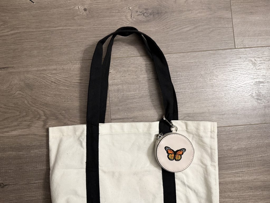 canvas tote bag with black straps and faux leather coin purse with butterfly patch