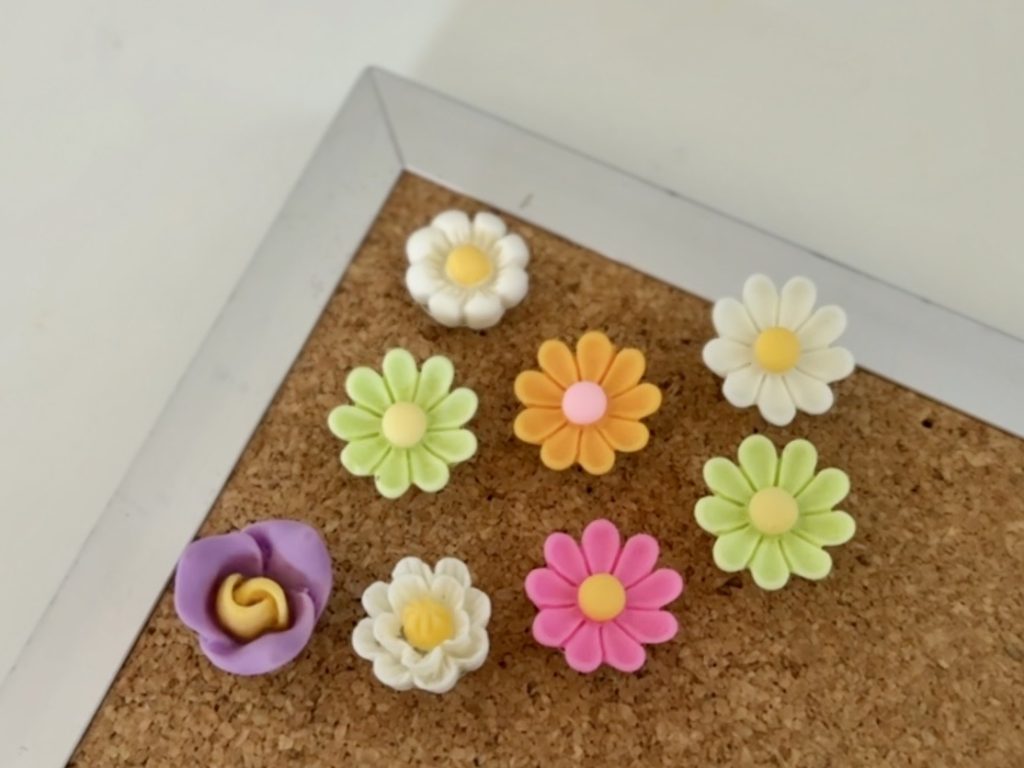 flower push pins on a cork board with silver frame